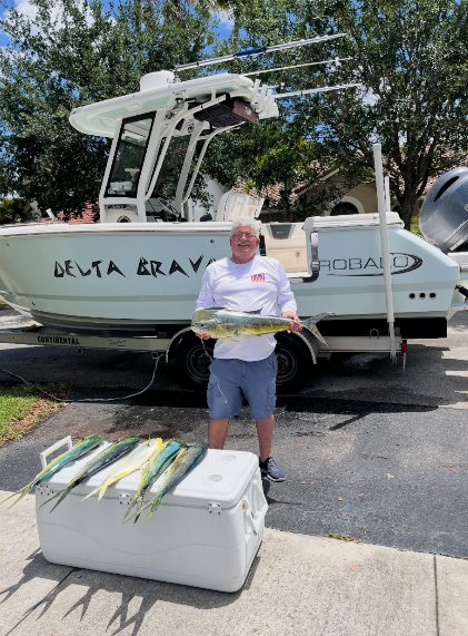 Captain Dan beside the Delta Bravo boat with catches